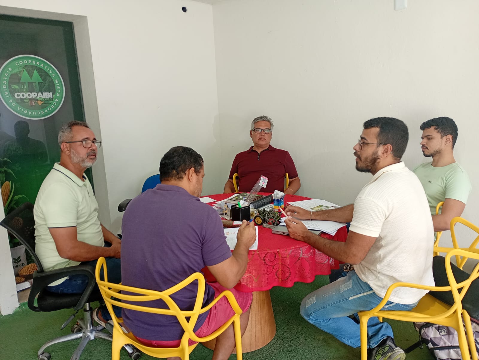 Representantes do CESOL Médio Rio das Contas e a diretoria da cooperativa à mesa.